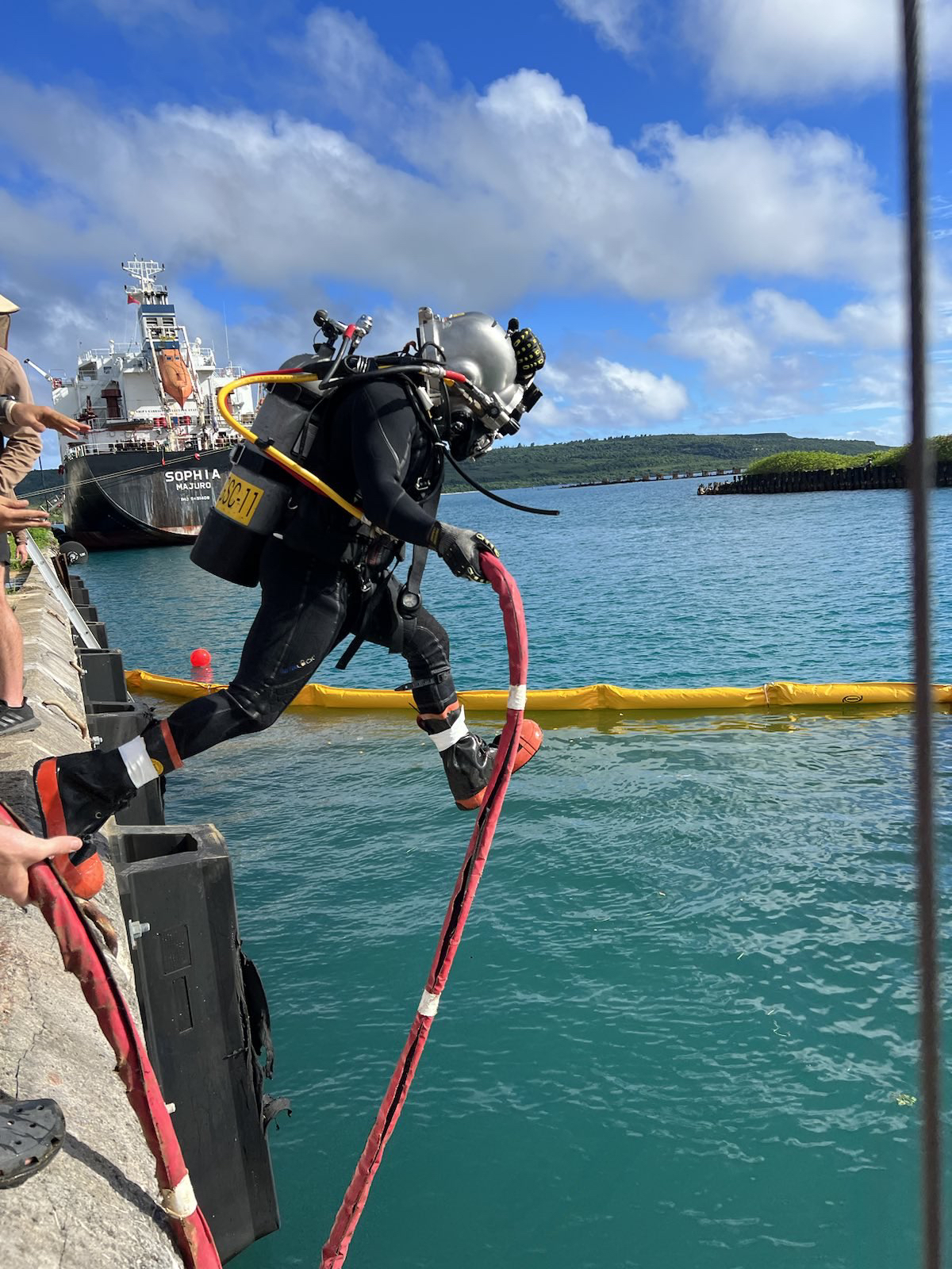 This is an image of a United States Navy diver entering the Port of Tinian.
